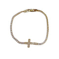 Gold-tone tennis bracelet with a sparkling cross centerpiece and clasp on white.