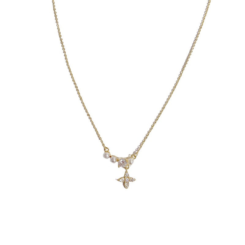 Gold-tone beaded chain necklace with a small star pendant on a white background.